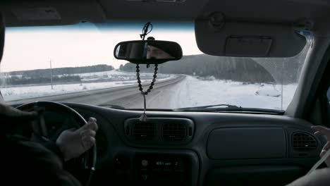 conduciendo a través de un paisaje nevado en un coche