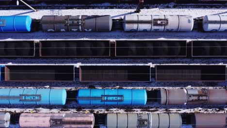 birdseye drone view of empty rail tankers and freight cars - katowice poland railway yard - winter industrial landscape with snow