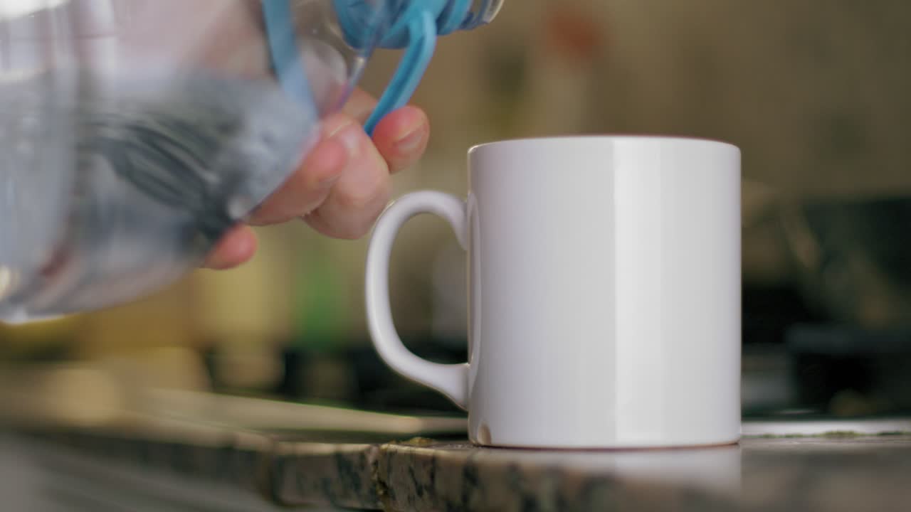 Pouring Water into a White Mug