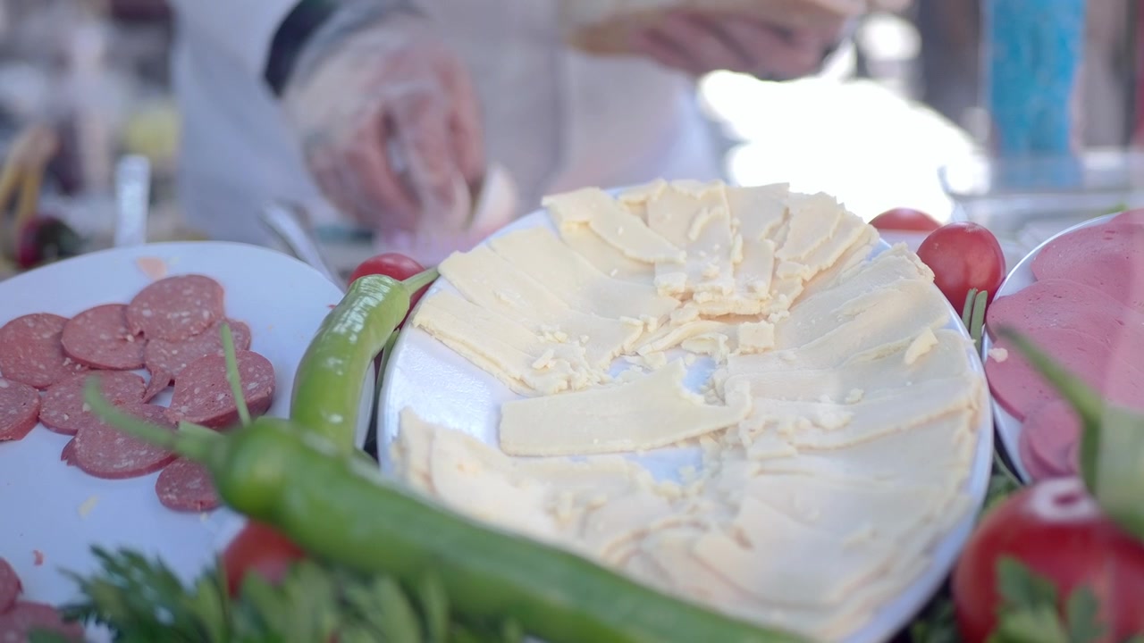 スライスされた肉とチーズを使った新鮮なサンドイッチを準備するシェフ