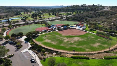 drone moving forward towards a baseball field inside alga norte park, carlsbad, california