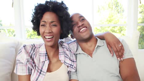 Pareja-Feliz-Viendo-Televisión-En-El-Sofá