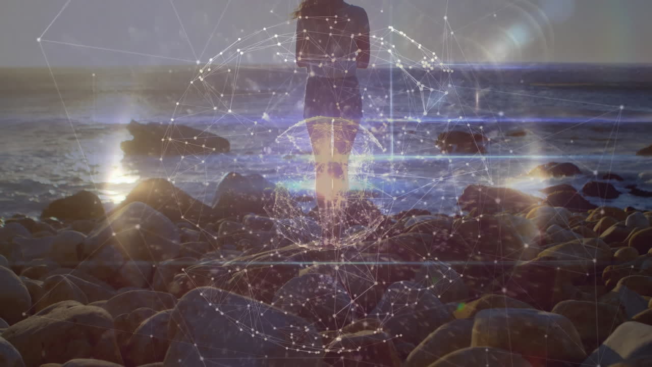 On rocky shore, person with digital network overlay in animation silhouette