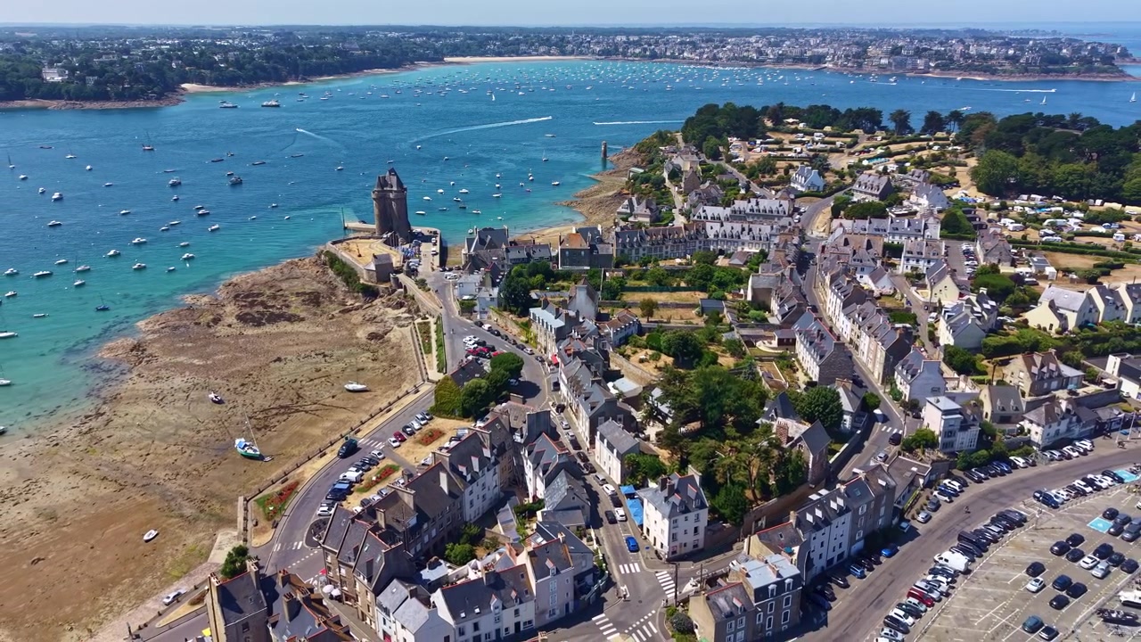 Pemandangan drone menara bersejarah Tour Solidor, pantai, dan perahu yang berlabuh di teluk di Saint-Malo, Brittany, Prancis. Mundur secara udara