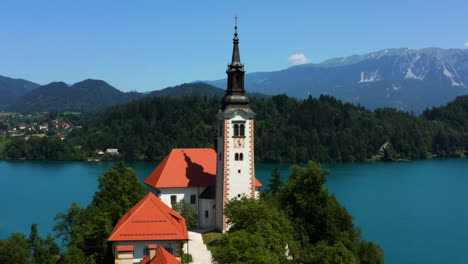 bled island - exterior view of cafe, provost house and pilgrimage church of the assumption of maria by the c in bled, slovenia