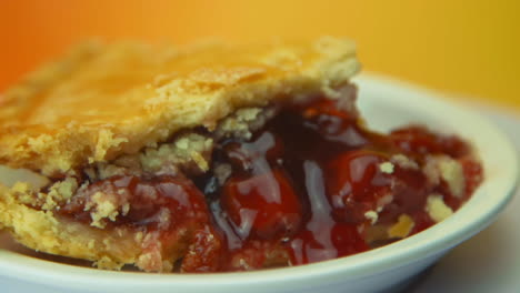 [cámara utilizada: canon c300] primer plano: una rebanada de pastel de cerezas giratoria, con corteza dorada y cerezas exudadas