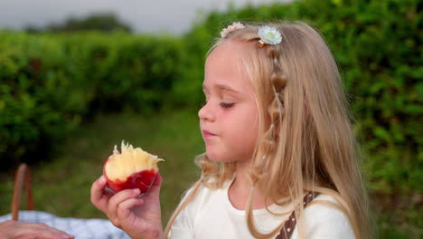 girl eating a peach in a orchard