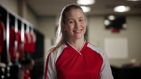 portrait of a smiling female athlete in a locker room