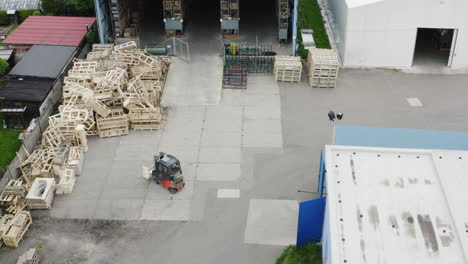 Loaded-forklift-truck-driving-out-of-warehouse-to-outdoor-cargo-hold