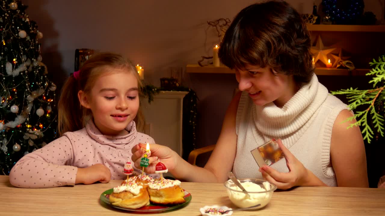 madre e hija encienden velas de navidad