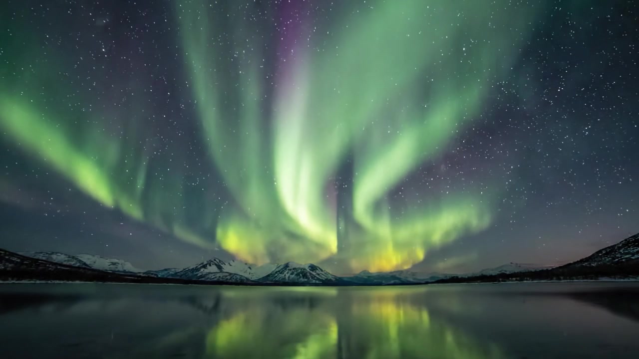 Danza ipnotizzante dell'aurora boreale: uno spettacolo mozzafiato che illumina il cielo notturno sopra maestose montagne e sereni riflessi su un lago calmo.