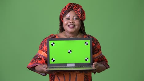 overweight beautiful african woman wearing traditional clothing against green background