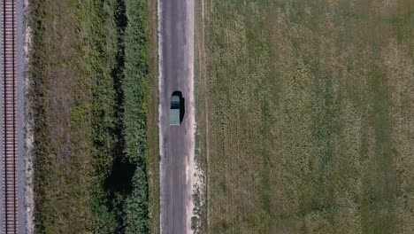 Drone-shot-of-Ukrainian-ambulance-rushing-across-the-field-on-a-dirt-road