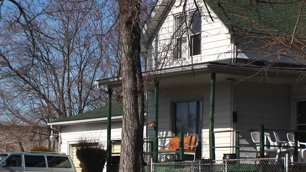 la cámara se desplaza desde el porche delantero de una casa residencial hasta una planta de energía nuclear ubicada cerca
