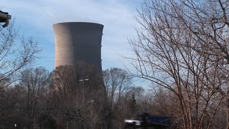 the camera pans from the front porch of a residential home to a nuclear power plant located nearby