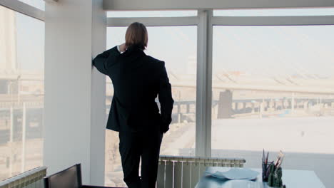 Businessman Contemplating at Office Window