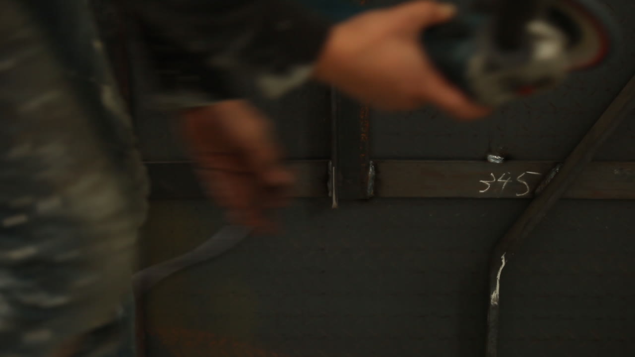 trabajador de fábrica que usa una amoladora angular para asegurarse de que la fabricación esté lista para pintar