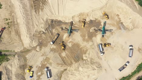 aerial view, machinery working at clay quarry, heavy loaders, large trucks, bulldozers, excavators, sand quarry, mining, truck takes raw materials from the quarry, large clay warehouse