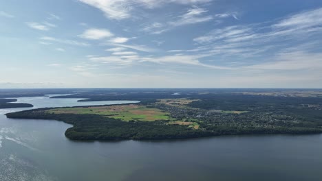 Panoramic-view,-large-lake,-shores-covered-with-green-trees,-sunny-summer-day,-nature-of-Baltic-countries