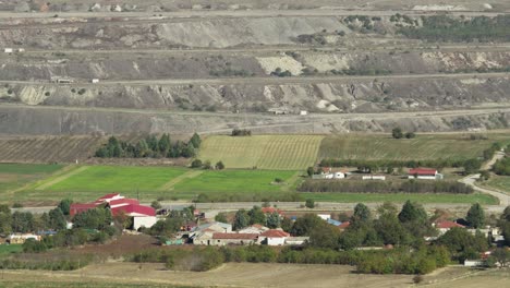 old lignite open massive mine field nex to village sunny day medium shot