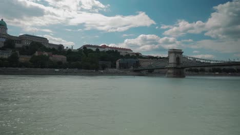 Boat-ride-through-Danube,-summer-afternoon-approaching-chain-bridge-passing-by-budacastle