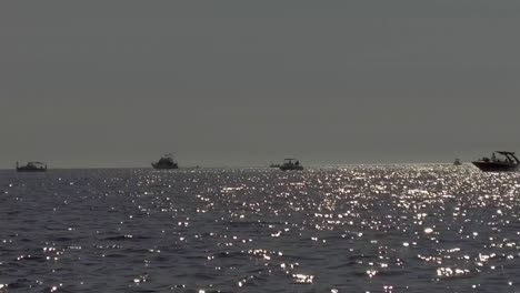 slow motion gimbaled shot of a group of boats fishing in the sea of cortez during late afternoon