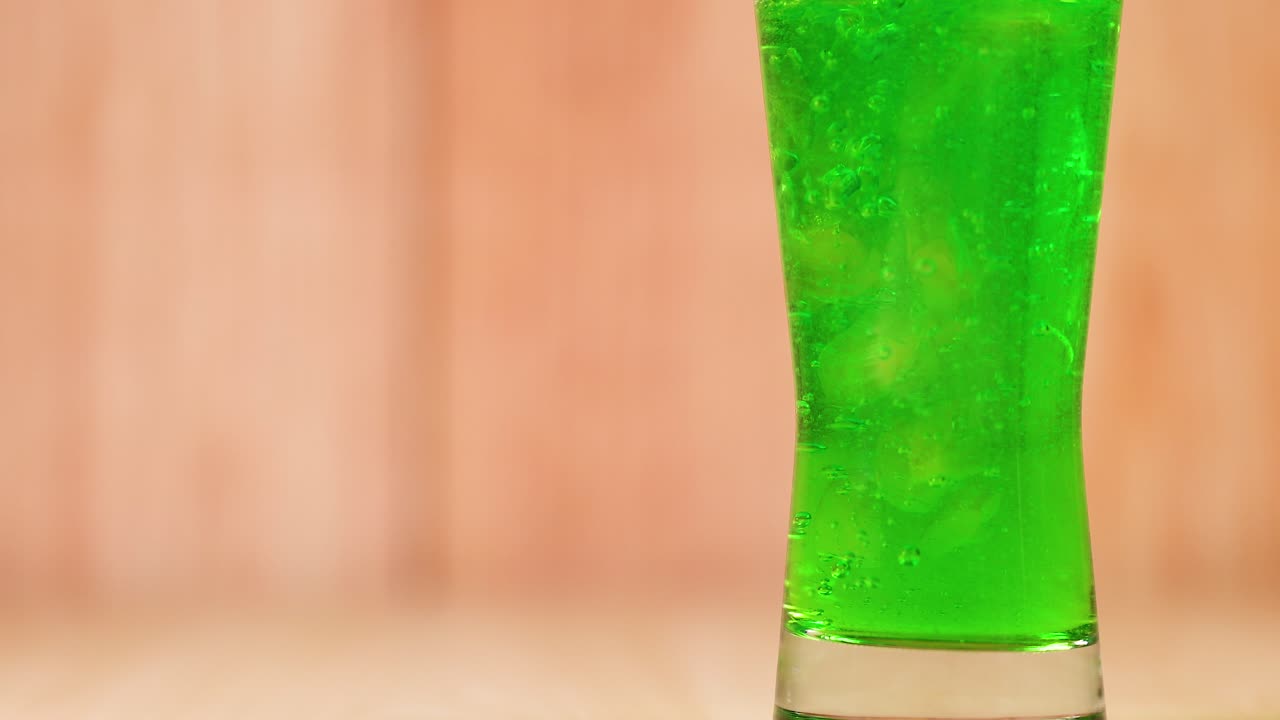Green liquid fills a clear glass