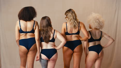 rear view of women friends one with prosthetic limb in underwear promoting body positivity