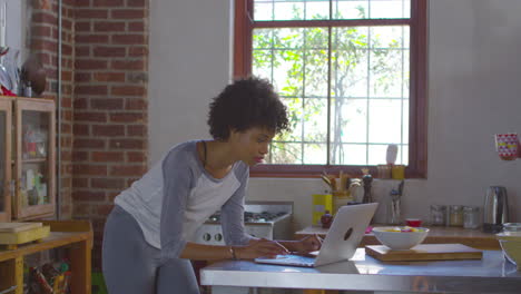 Pareja-Negra-Usando-Una-Computadora-En-La-Cocina-Y-Tomando-Café,-Filmada-En-R3d