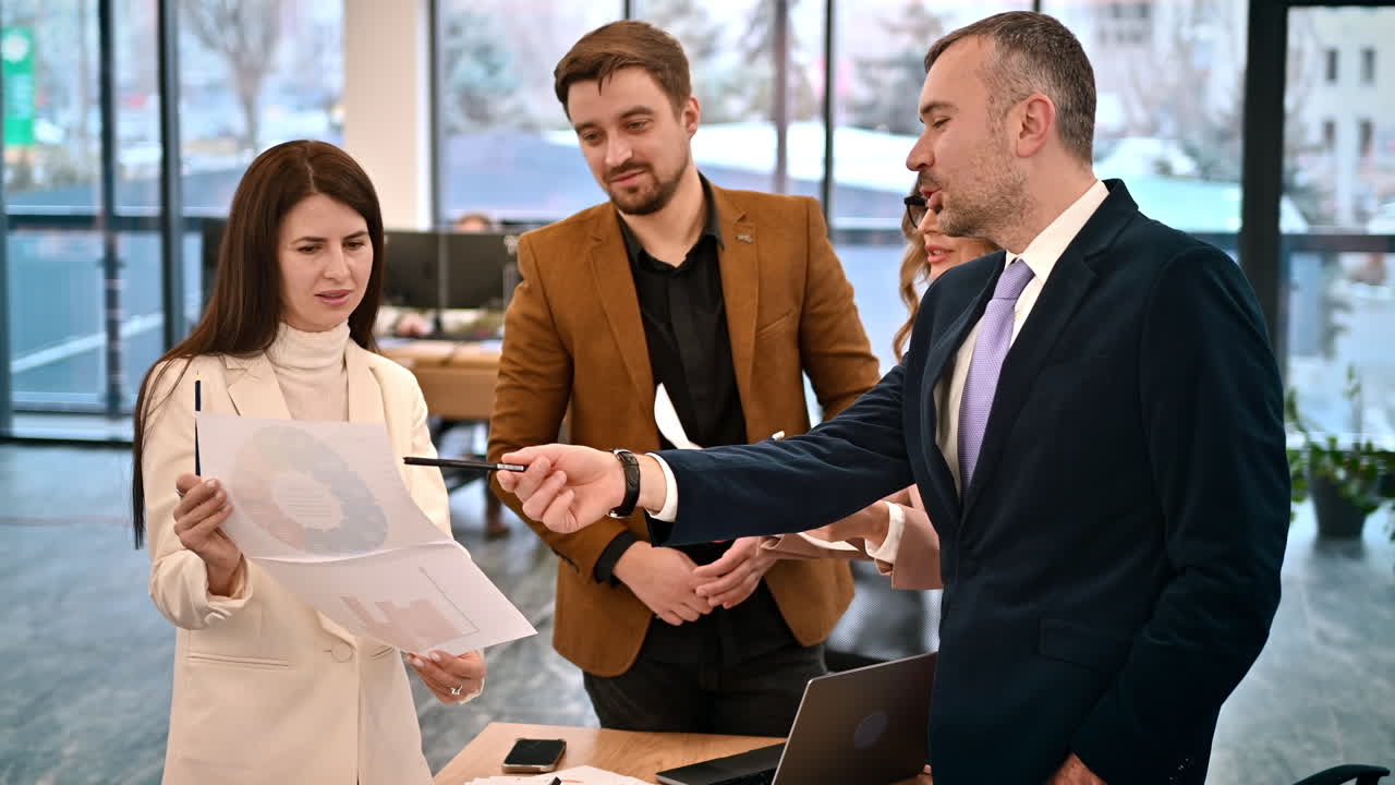 Riunione di lavoro in un ufficio, persone che discutono di affari usando documenti con grafici. Rallentatore