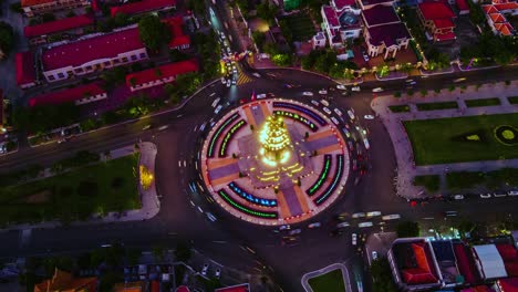 traffic around illuminated independence monument in phnom penh, cambodia - sunset to night hyperlapse - aerial