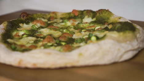 sartén a cámara lenta de izquierda a derecha de una deliciosa pizza italiana casera con una corteza de masa fermentada lista para ser cortada y disfrutada por toda la familia