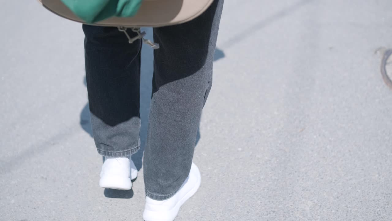 숲 근처의 거리에서 기타를 들고 는 젊은 남자