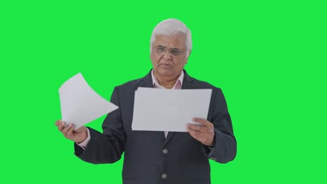 gerente senior indio leyendo informes pantalla verde