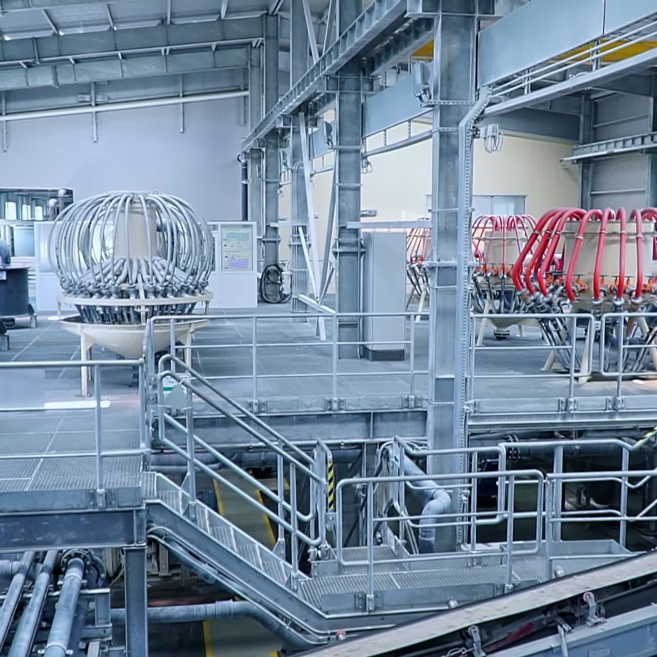 Nastro trasportatore in movimento con argilla caolinica. Tubi e condutture in acciaio presso le apparecchiature per la lavorazione dell'argilla
