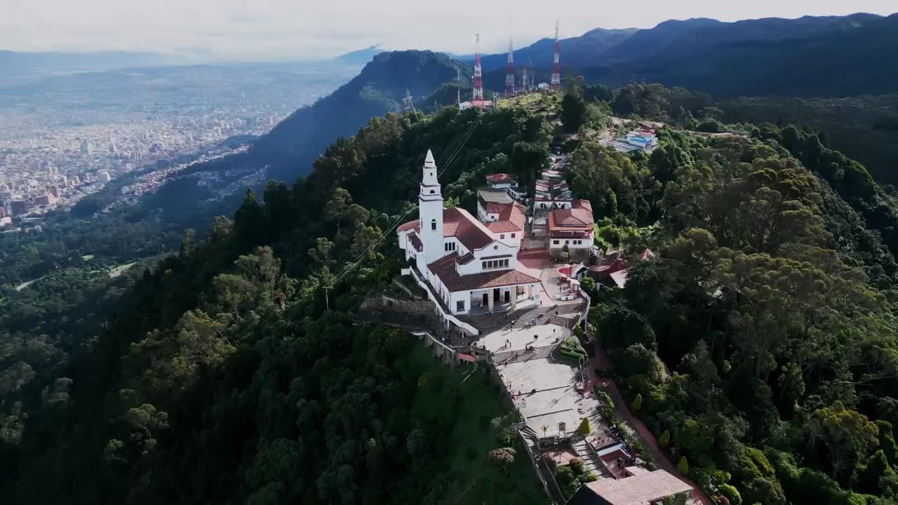 Wide drone view panning around Monserrate Park Hill Mountain in Bogotá, Colombia.