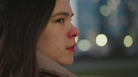 흐릿한 배경에 있는 소녀의 얼굴의 클로즈업, 그녀의 눈을 이는 것을 포착합니다. 친밀한 은 그녀의 섬세한 특징을 강조하고 조용한 분위기에 역동적이고 자연스러운 터치를 추가합니다.