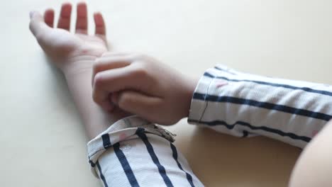 rear view of child suffering itching skin on hand ,