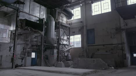 A-tilt-shot-starting-at-the-ceiling-with-the-metal-catwalk-down-to-the-old,-ripper-apart-ventilation-system-of-an-abandoned-factory