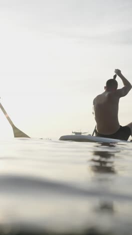 people paddleboarding at sunset