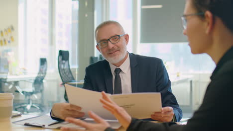senior ceo discussing report with female colleague