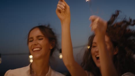 Group-friends-dancing-together-at-the-rooftop-with-sparkles.