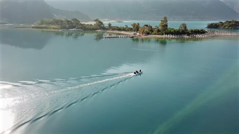 aerial view of a boat on a calm turquoise sea near a small island