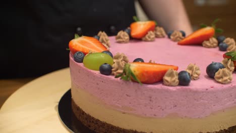 Mujer-Decorando-Pastel-De-Crema-Con-Fruta-De-Uva