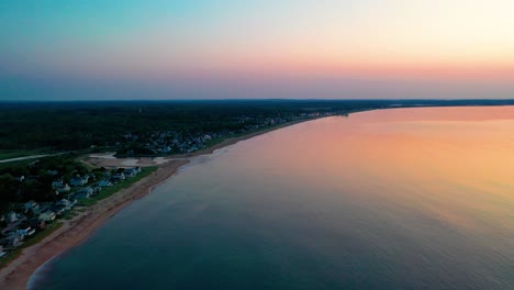 Puesta-De-Sol-Sobre-Casas-De-Playa-Con-Colores-Que-Se-Reflejan-En-Las-Olas-Del-Océano-Y-Casas-De-Vacaciones-A-Lo-Largo-De-La-Costa-Atlántica-De-Nueva-Inglaterra