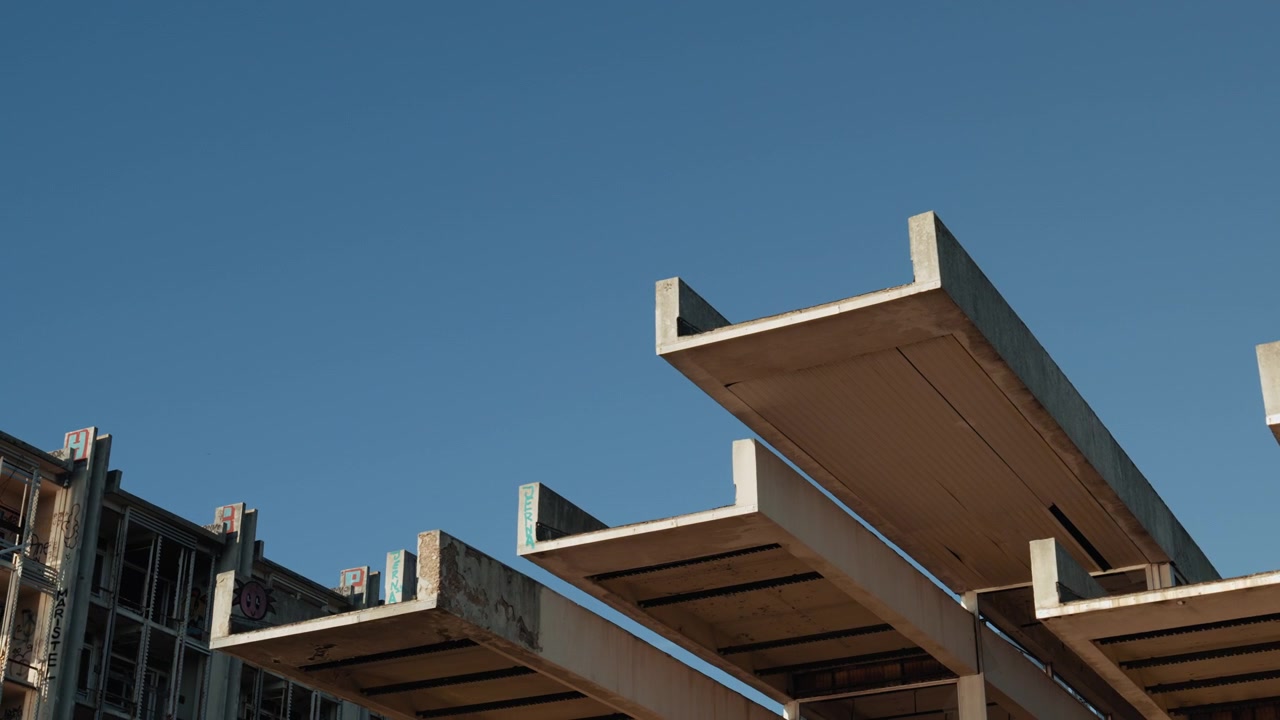 Close view of geometric concrete architecture at an abandoned resort complex with minimalist brutalist design and clear blue sky in Croatia.