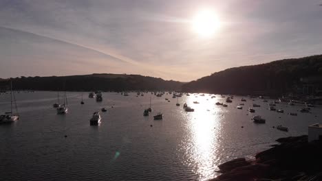 Aerial-sunset-view-of-the-Fowey-Harbour-in-Cornwall-with-small-boats,-capturing-tranquility-and-beauty