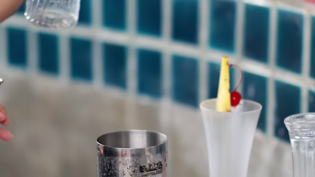 el camarero mezcla hábilmente los ingredientes para un cóctel.