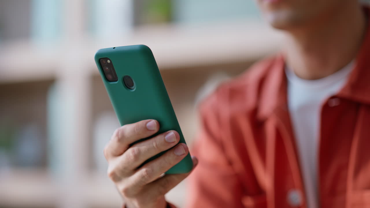 Blogger hand touching smartphone posting in social media in apartment closeup