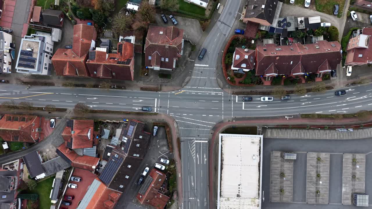 Flygbild ovanifrån av trafikscen vid en korsning i en tysk stad. Röda tegeltak på hus i en historisk stad. Nedåtgående tagning. Körande bilar på vägen. Fridfull scen under senhösten, tidig vinter